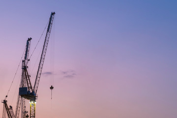 Construction cranes at sunset with copy space