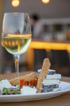 Simply  Hand-picked Cheese Platter Of Artisan Cheeses Fruit And Nuts With A Glass Of White Wine