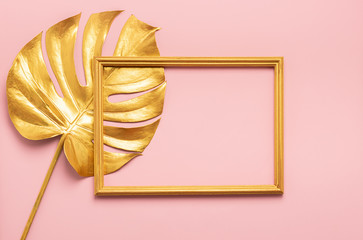 The square frame and leaf of tropical monstera plant are painted in gold color pink background. Art concept minimalism.