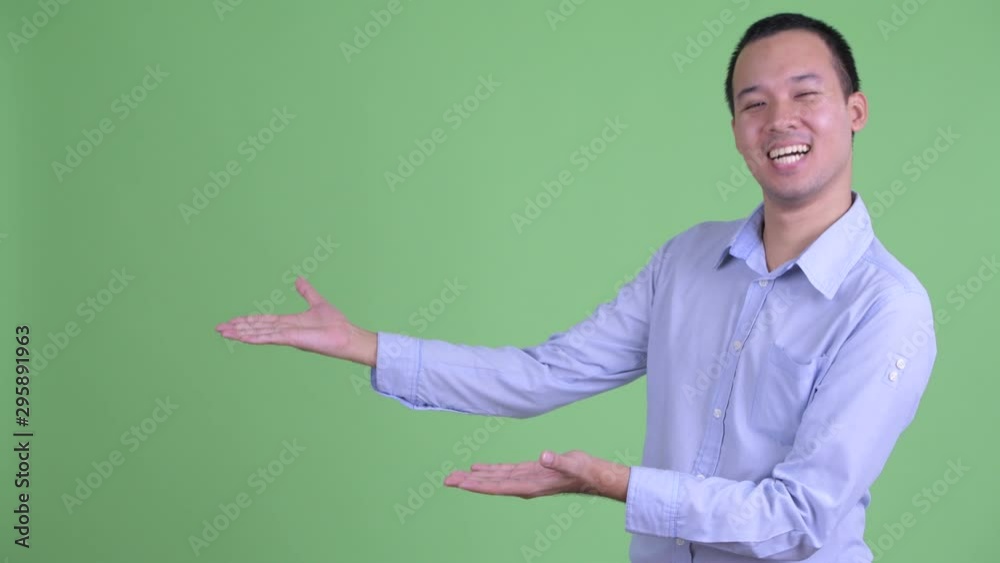 Poster Happy Asian businessman showing something