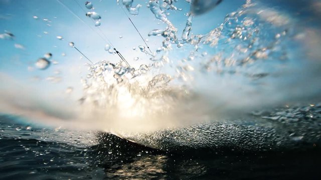 A kitesurfer splashing water while riding a board. Kite surfer kiteboarding.