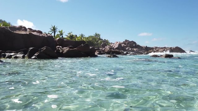 landscape of natural pool in La Digue, Seychelles Islands. Turquoise calm waters of swimming pools at popular Anse Cocos near Grand Anse and Petite Anse protected by rock formations.