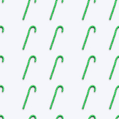 Seamless pattern of Christmas candy cone on white background. Colorful holiday sweet lollipop. Dessert wtih green and white stripes.