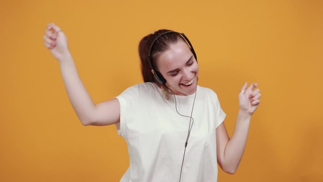 Girl enjoys rock music. She is that much relaxed and joyful that dances around up and down which shows the music is definitely very good.