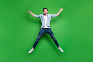 Obraz premium Full size photo of handsome guy jumping high in star shape celebrating sport competition first place winning wear casual denim outfit isolated green color background