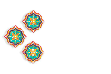 Happy Diwali - Clay Diya lamps lit during Dipavali, Hindu festival of lights celebration. Colorful traditional oil lamp diya on white background. Copy space for text.