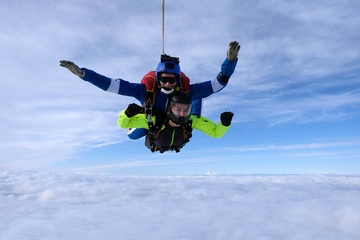 Skydiving. Tandem jump. An instructor and a passenger are flying  in the sky.