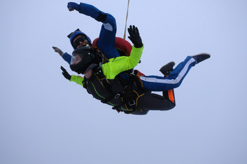 Fototapeta na wymiar Skydiving. Tandem jump. An instructor and a passenger are flying in the sky.