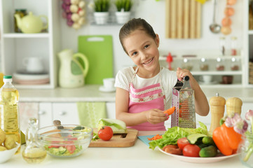 Portrait of girl preparing delicious fresh salad in kitchen