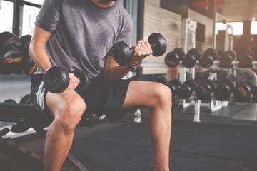 Closeup of a thin man doing exercises with dumbbell. Fitness muscular body. Fitness concept