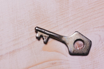 the iron key lies on a white wooden surface