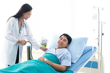 The doctor is the pressure gauge. The patient is lying in a hospital bed.female doctor with happy patient at the hospital.