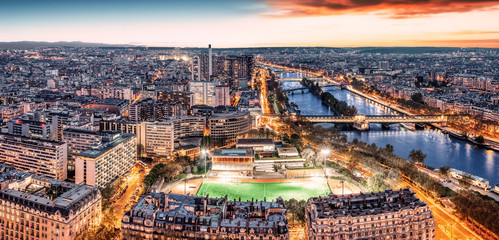 Paris city skyline rooftop view with River Seine at night, France. Evening panorama.
