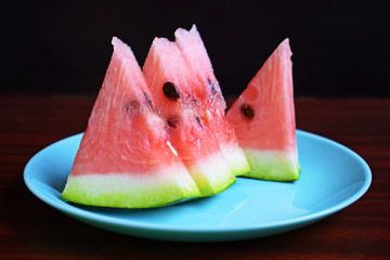 Delicious sweet watermelon cut into pieces on wooden background.