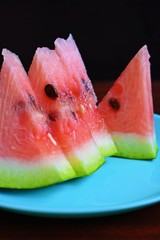 Delicious sweet watermelon cut into pieces on wooden background.