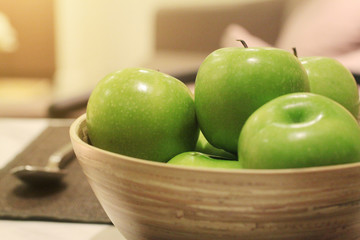Freshness green apple in wood bowl decoration on dining table