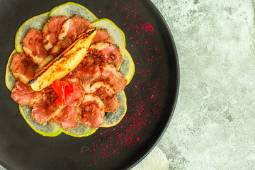 duck meat carpaccio with pear flambe (tasty snack, aperitif) menu concept. food background. copy space. Top view