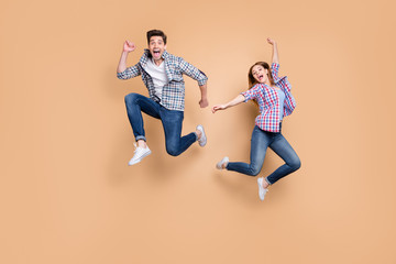 Fototapeta na wymiar Full length photo of two people crazy lady guy jumping high overjoyed mood celebrate sale shopping prices black friday wear casual clothes isolated beige color background