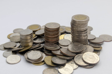 Many Thai coins are stacked together on a white background. Conceptual interpretation of means to expand Whether saving money or investing For the growth to grow even more For stability in the future