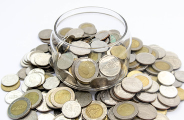 Thai coins in a glass and a pile on a white background Conceptual interpretation of means to expand Whether saving money or investing For the growth to grow even more For stability in the future