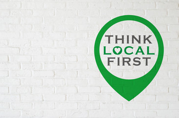THINK LOCAL FIRST と書かれた煉瓦壁