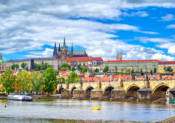 Obraz premium A view across the Charles Bridge and the Vltava River to Prague Castle and St. Vitas Cathedral in Prague, Czech Republic.