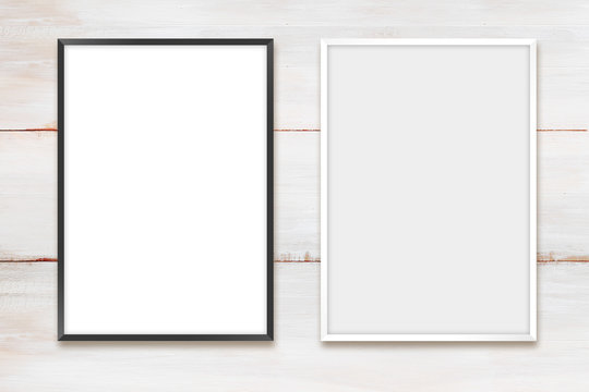  White and black photo frames on a wooden wall