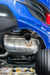 Obraz na płótnie Canvas Close up horizontal shot of a blue car exhaust pipe.