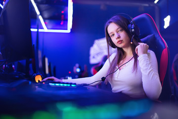 Streamer beautiful girl professional gamer smile playing online games computer with headphones, neon color - obrazy, fototapety, plakaty