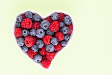 Creative layout made of Blueberry and raspberries on pastel background. Food ingredient pattern.