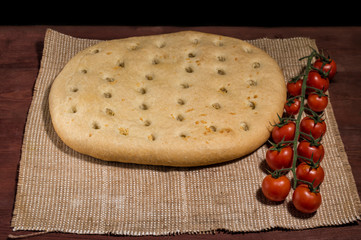 Closeup of Italian focaccia with cherry tomatoes on burlap