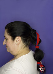 Fototapeta premium Woman with pigtail decorated with a red bow