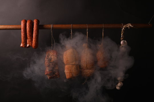 Traditional smokehouse. Sausages, hams and bacon surrounded by smoke in a smokehouse.