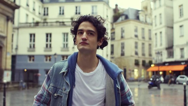 Front view of a young man walking in the streets of Paris