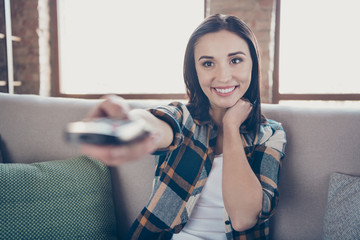 Photo of amazing lady going to watch favorite humor tv show holding remote controller sitting comfy sofa wearing casual clothes apartment indoors