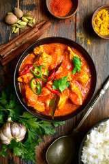 Chicken tikka masala - traditional dish of indian cuisine in a clay bowl .