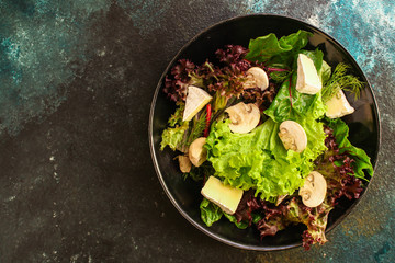 healthy salad mushrooms, cheese and green leaves (snack dish, vegetables, arugula, lettuce, spinach and more) menu concept. food background. copy space. Top view