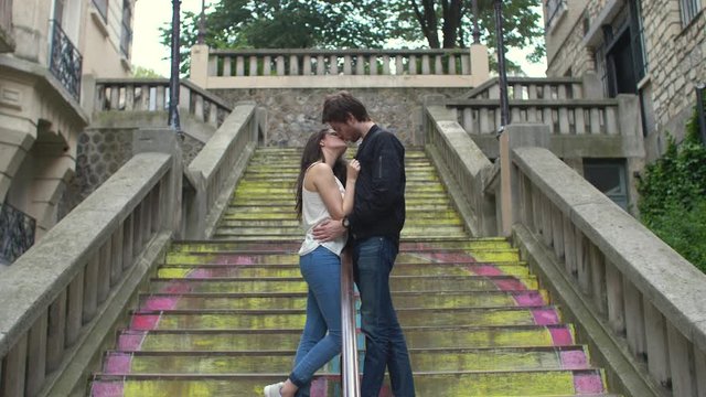 Couple kissing on steps in Paris, France