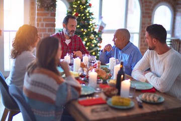 Beautiful family smiling happy and confident. Eating roasted turkey celebrating Christmas at home