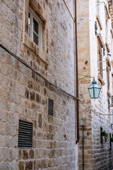 Stone house and lantern in narrow stone street in old historic Dubrovnik city, Dalmatia, Croatia, the most popular touristic destination