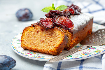 Sliced plum cake with almonds and spiced plum.