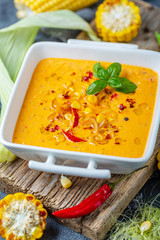 Homemade creamy corn soup in a porcelain saucepan.