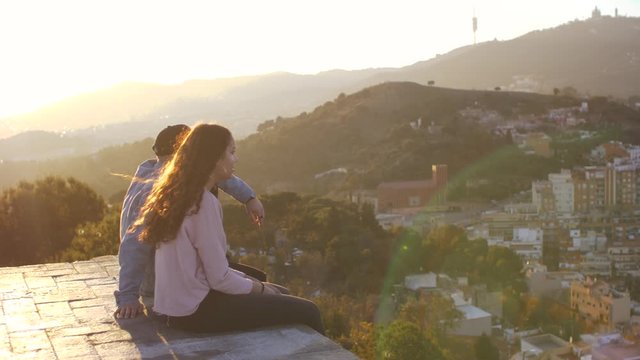 Three friends looking the city of Barcelona at sunset