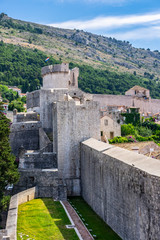 Fototapeta na wymiar View of Dubrovnik city stone walls and hills in background, Dalmatia, Croatia, sunny summer day, the most popular touristic travel destination 