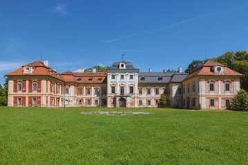 Old castle in Czech Republic. Green lawn with blue sky.