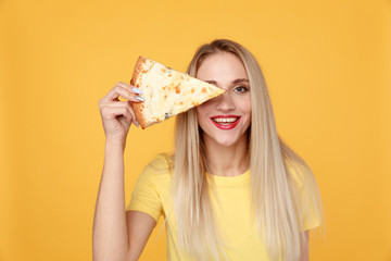 Attractive woman with slice of pizza isolated over the yellow background