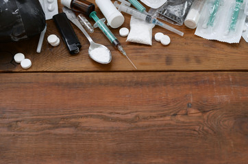 A lot of narcotic substances and devices for the preparation of drugs lie on an old wooden table