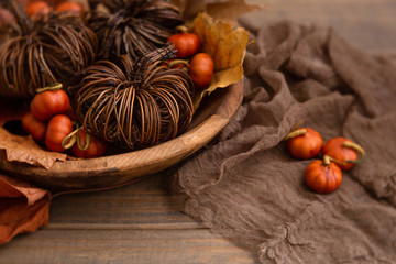 Obraz na płótnie Canvas Rustic Fall Table Centerpiece; Brown Twig Pumpkins and Small Orange Pumpkins in Wooden Bowl