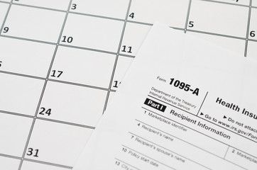 IRS Form 1095-A Health Insurance Marketplace Statement tax blank lies on empty calendar page