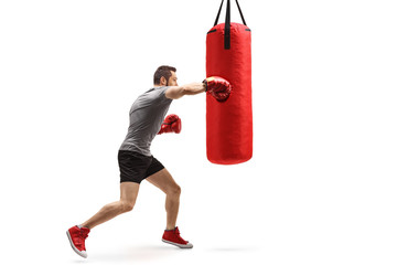 Young muscular man training box with a punching bag
